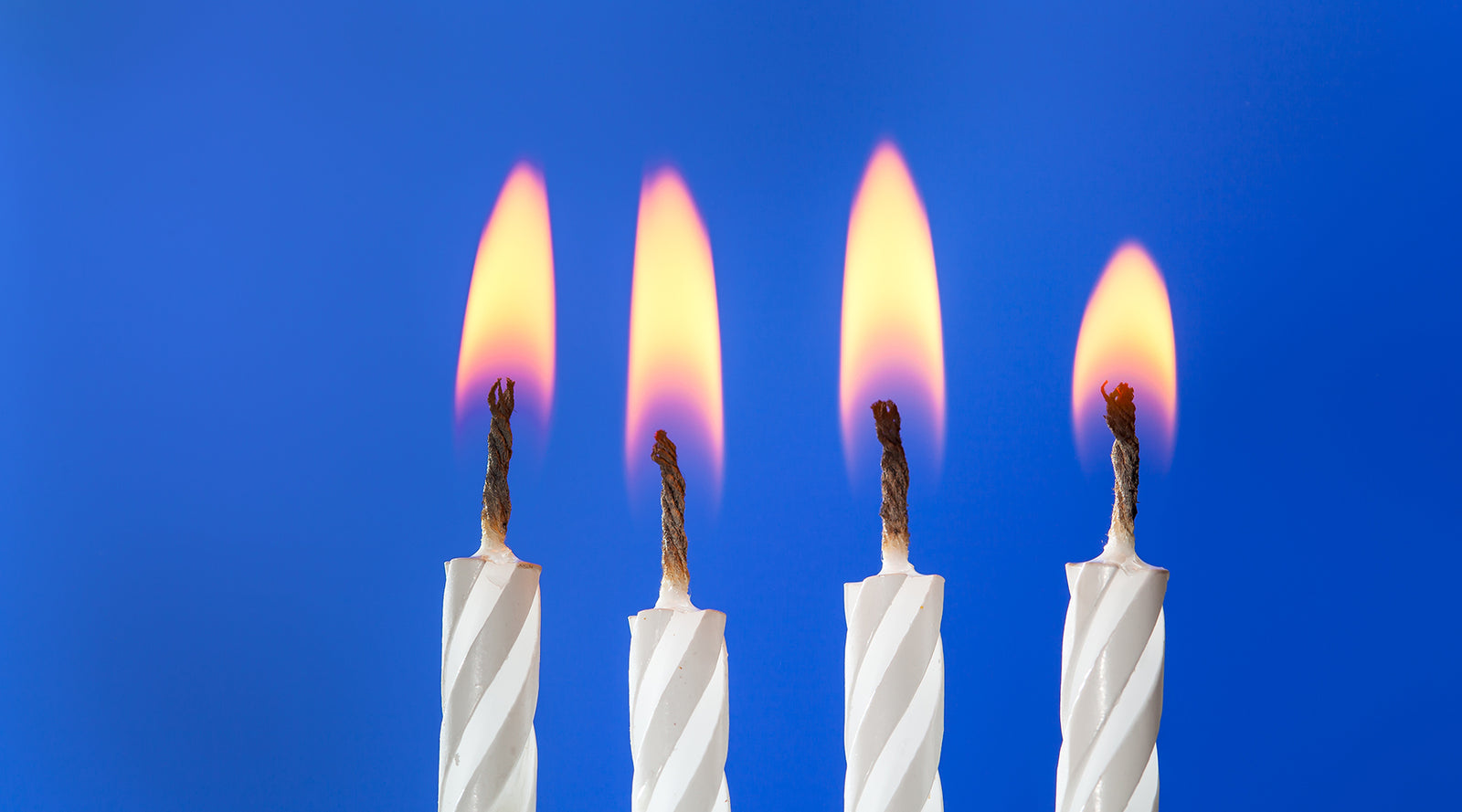 Four white cake candles burning in a row | Nikki Darling Australia