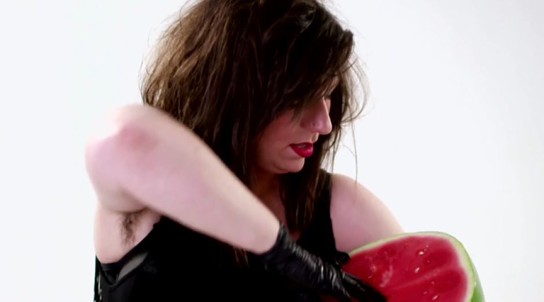 Maeve Marsden wearing black latex glove fisting watermelon - still from Lady Sings It Better x CLAUDE campaign | Nikki Darling Australia